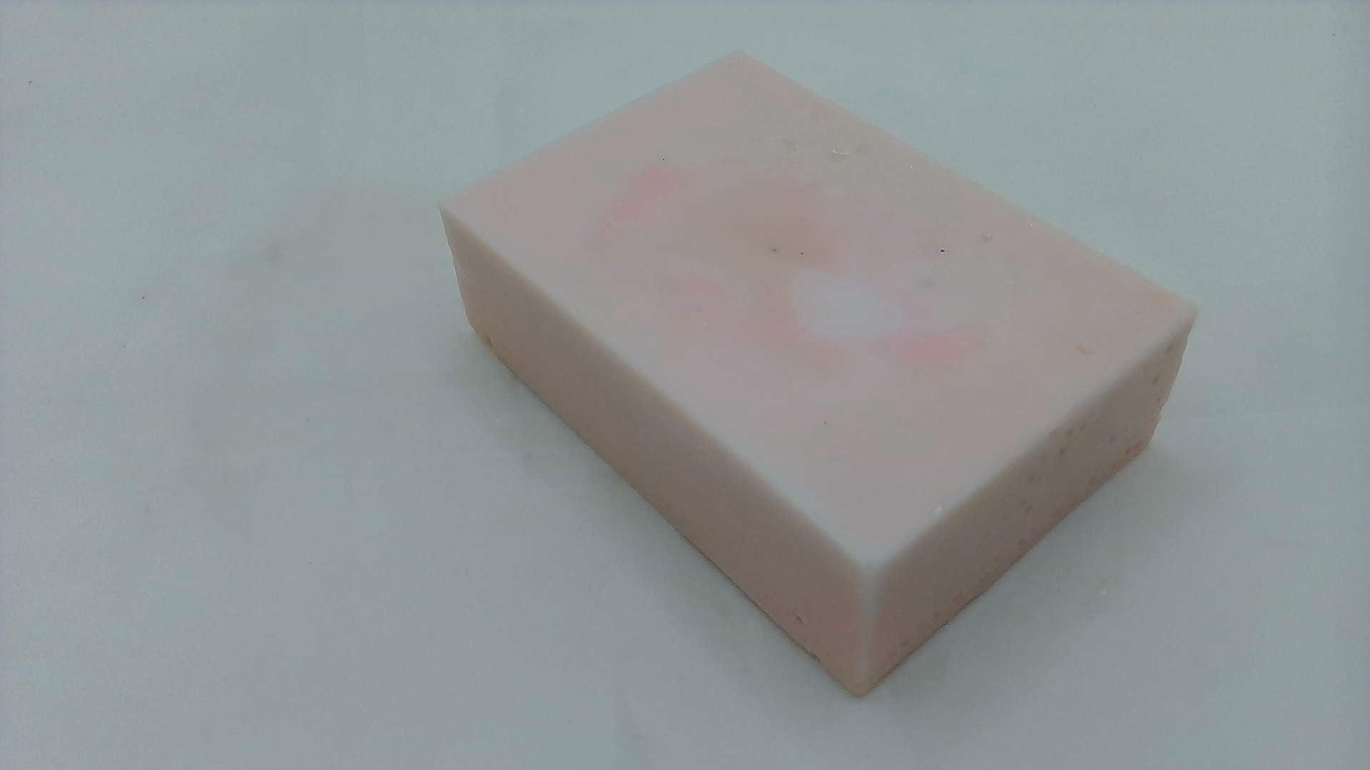 a pink square shaped object on a white surface