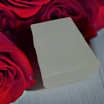 a close up of a soap block on a bed of red roses