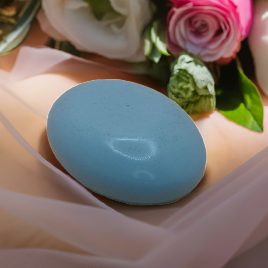 a blue soap sitting on top of a table next to flowers