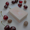 a bar of soap surrounded by cherries and nuts