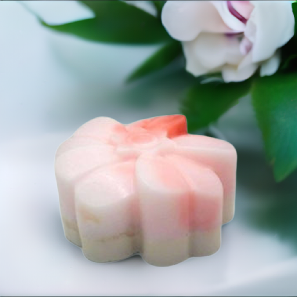 a close up of a candle with a flower in the background