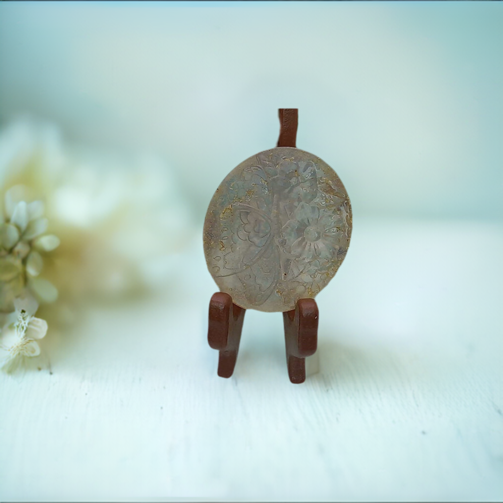 a small figurine sitting on a table next to a flower