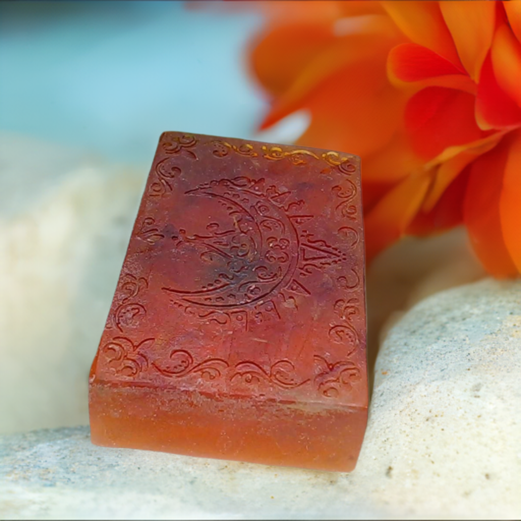 a piece of soap sitting next to a flower