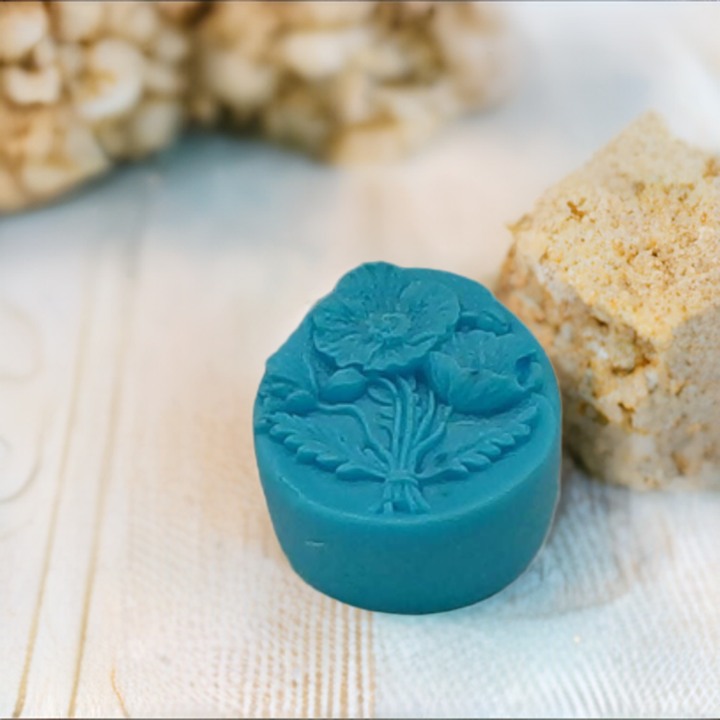 a blue wax stamp sitting next to a piece of cake