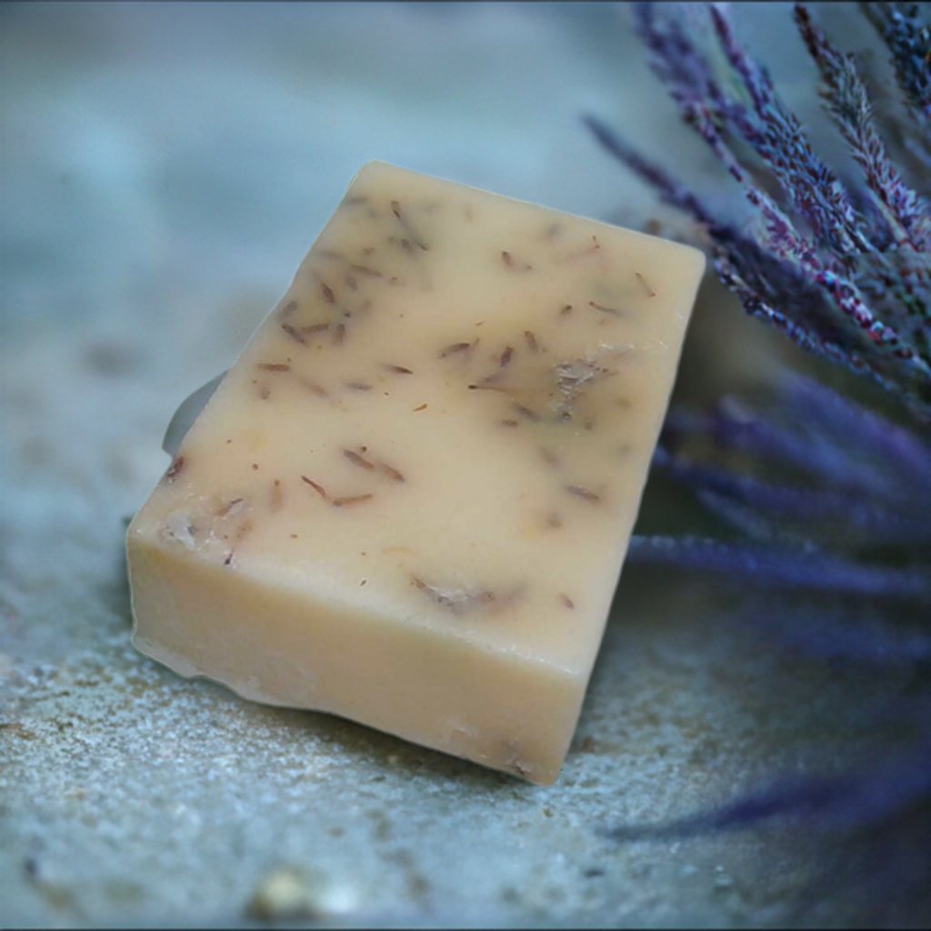 a bar of soap sitting next to a purple plant