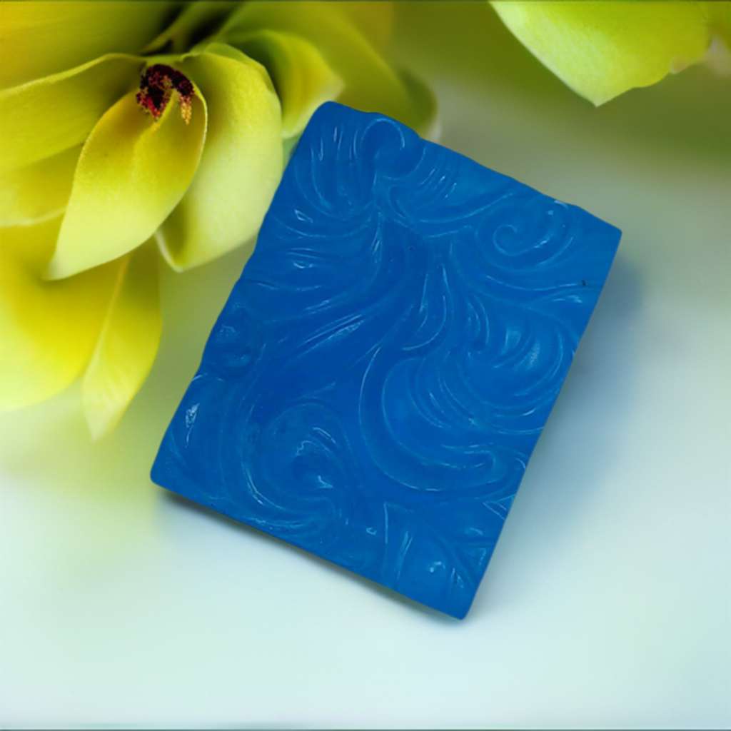 a blue soap sitting next to a yellow flower